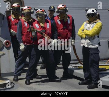 U.S. Navy sailors perform a crash and salvage drill on the USS Arleigh ...