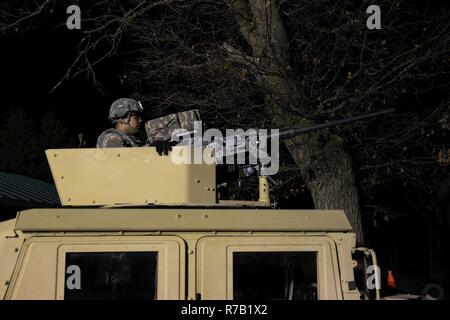 A U.S. Army Reserve Soldier with 325th Psychological Operations Company (Airborne), U.S. Army Civil Affairs and Psychological Operation Command, prepares for basic night live-fire during Operation Cold Steel at Fort McCoy, Wis., April 11, 2017. Operation Cold Steel is the U.S. Army Reserve's crew-served weapons qualification and validation exercise to ensure that America's Army Reserve units and Soldiers are trained and ready to deploy on short-notice and bring combat-ready and lethal firepower in support of the Army and our joint partners anywhere in the world. Stock Photo