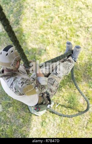 An EOD technician fast ropes from an SH-60 Seahawk during HRST master ...