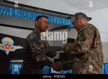 Lt. Col. Bulat Dusembayev, commander of the Kazakhstan Peacekeeping Brigade, left, presents Lt. Col. James Becker, 352nd Civil Affairs Command, with a certificate of appreciation during the closing day of Steppe Eagle Koktem, Apr. 11, 2017, at Illisky Training Center, Kazakhstan. Stock Photo