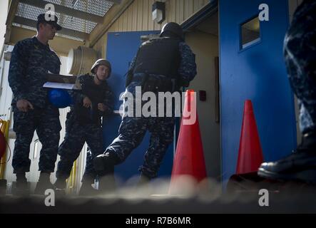 NORFOLK (May 04, 2017) Sailors assigned to the aircraft carrier USS George Washington’s (CVN 73) security reaction force enter the ship’s floating accommodation facility during an anti-terrorism training team evolution involving an active shooter drill. George Washington is homeported in Norfolk preparing to move to Newport News, Virginia for the ship’s refueling complex overhaul (RCOH) maintenance. Stock Photo