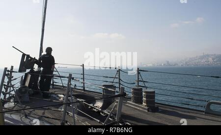 HAIFA, Israel (May 7, 2017) Information Systems Technician 3rd Class Ryan Guerra, from Philadelphia, mans a .50-caliber machine gun aboard the Arleigh Burke-class guided-missile destroyer USS Ross (DDG 71) while arriving in Haifa, Israel, for a scheduled port visit May 7, 2017. Ross, forward-deployed to Rota, Spain, is conducting naval operations in the U.S. 6th Fleet area of operations in support of U.S. national security interests in Europe and Africa. Stock Photo