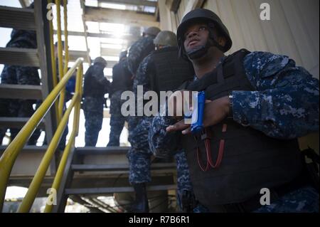 NORFOLK (May 04, 2017) Damage Controlman 3rd Class Thaddeus Malone, from Gallatin, Tennessee and assigned to the aircraft carrier USS George Washington’s (CVN 73) security reaction force, watches the perimeter of the ship’s floating accommodation facility during an anti-terrorism training team evolution involving an active shooter drill. George Washington is homeported in Norfolk preparing to move to Newport News, Virginia for the ship’s refueling complex overhaul (RCOH) maintenance. Stock Photo