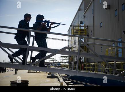 NORFOLK (May 04, 2017) Sailors assigned to the aircraft carrier USS George Washington’s (CVN 73) security reaction force advance toward the ship’s floating accommodation facility during an anti-terrorism training team evolution involving an active shooter drill. George Washington is homeported in Norfolk preparing to move to Newport News, Virginia for the ship’s refueling complex overhaul (RCOH) maintenance. Stock Photo