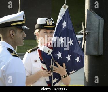 Lt. jg. Tigran Sadoian and Lt. jg. Caylin Schultz, nurses, perform morning colors during a ceremony celebrating Nurses Week, May 10, 2017. NHCL Officers, Sailors and Civilians gathered in formation to observe the ceremony. Stock Photo