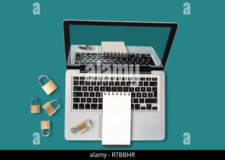Top view of a laptop, padlocks and a notepad with copyspace, a security concept