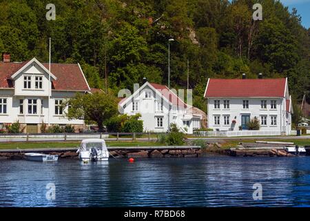 traditional norwegian wooden house to stand at the lakeside and mountains in the distance, norway Stock Photo