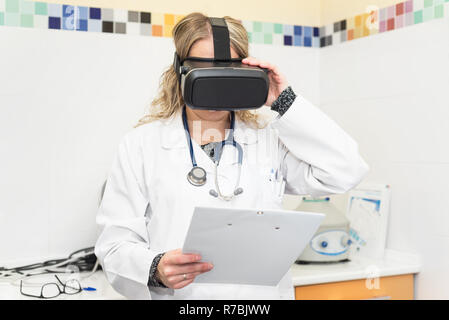 Scientist with clipboard using virtual reality glasses for research in laboratory Stock Photo