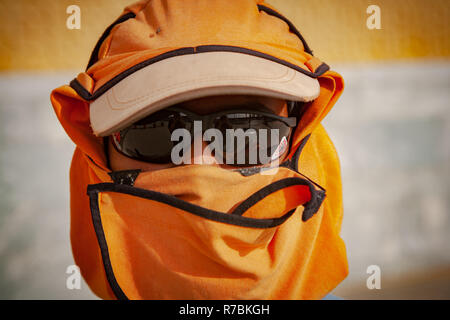 Worker wearing sunglasses with hats and head covering on a construction site in Dubai, UAE Stock Photo