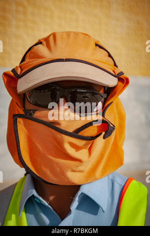 Worker wearing sunglasses with hats and head covering on a construction site in Dubai, UAE Stock Photo