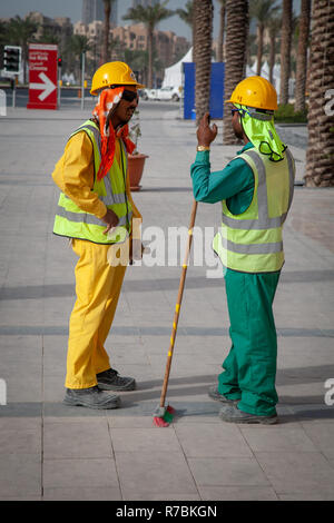Two building workers talking to each other on a building site in Dubai, UAE Stock Photo