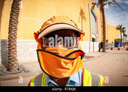 Worker wearing sunglasses with hats and head covering on a construction site in Dubai, UAE Stock Photo