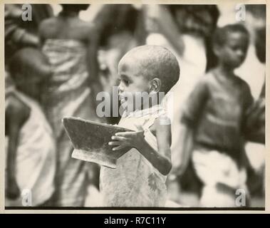 little boy carrying a bowl Stock Photo