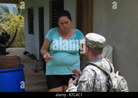 U.S. Army Capt. Stuart Cowell, with the 71st Theater Information Operation Group, 102nd General Support Battalion, based out of Austin, Texas, informs a citizen of an upcoming medical event happening in Dangriga City, while visiting Valley Community, Belize, May 13, 2017. Dangriga is home for the next medical readiness event to be held during Beyond the Horizon 2017. BTH 2017 is a U.S. Southern Command-sponsored, Army South-led exercise designed to provide humanitarian and engineering services to communities in need, demonstrating U.S. support for Belize. Stock Photo