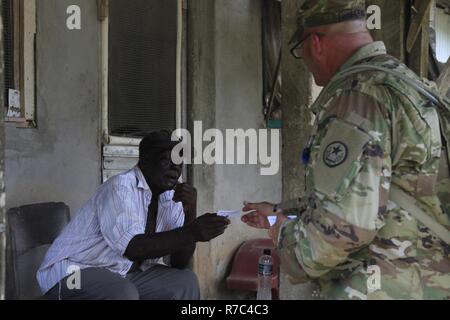 U.S. Army Sgt. 1st Class Scott Jarvis, with the 71st Theater Information Operation Group, 102 General Support Battalion, based out of Austin, Texas, informs a citizen of an upcoming medical event happening in Dangriga City, while visiting Valley Community, Belize, May 13, 2017. Dangriga is home for the next medical readiness event to be held during Beyond the Horizon 2017. BTH 2017 is a U.S. Southern Command-sponsored, Army South-led exercise designed to provide humanitarian and engineering services to communities in need, demonstrating U.S. support for Belize. Stock Photo