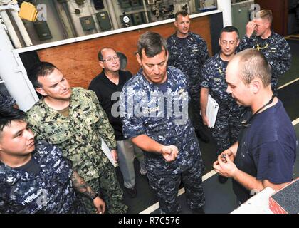 (POLARIS POINT, Guam) May 16, 2017 -- Rear Adm. Stephen Williamson, Director of Fleet Maintenance, U.S. Pacific Fleet, inspects the quality and craftsmanship of Machinery Repairman Fireman Walter Iverson's machined product during a tour aboard submarine tender USS Emory S. Land (AS 39), May 16. Williamson toured the ship and other repair facilities in Guam to assess current maintenance operations and capabilities. Land and USS Frank Cable (AS 40), the U.S. Navy’s only two submarine tenders, are both homeported in Apra Harbor, Guam, and provide maintenance, hotel services, and logistical suppor Stock Photo