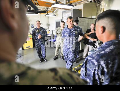 (POLARIS POINT, Guam) May 16, 2017 Rear Adm. Stephen Williamson, Director of Fleet Maintenance, U.S. Pacific Fleet, discusses the importance of maintenance to the submarine tender USS Emory S. Land's (AS 39) Mechanical Repair division during a shipboard tour, May 16. Williamson toured the ship and other repair facilities in Guam to assess current maintenance operations and capabilities. Land and USS Frank Cable (AS 40), the U.S. Navy’s only two submarine tenders, are both homeported in Apra Harbor, Guam, and provide maintenance, hotel services, and logistical support to submarines and surface  Stock Photo