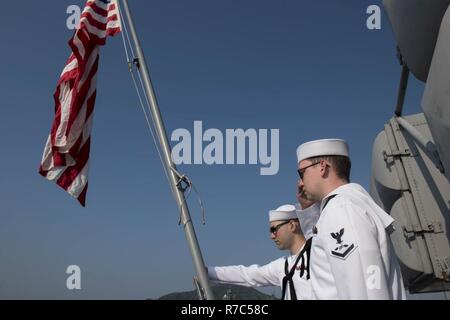 SASEBO, Japan (May 18, 2017) Aviation Electronics Technician Airman Jacob Gonzales (left), from Austin, Texas and Aviation Electronics Technician 3rd Class Patrick Allen, from Cincinnati, conduct morning colors aboard the amphibious assault ship USS Bonhomme Richard (LHD 6). Bonhomme Richard, forward-deployed to Sasebo, Japan, is serving forward to provide rapid-response capability in the event of a regional contingency or natural disaster. Stock Photo
