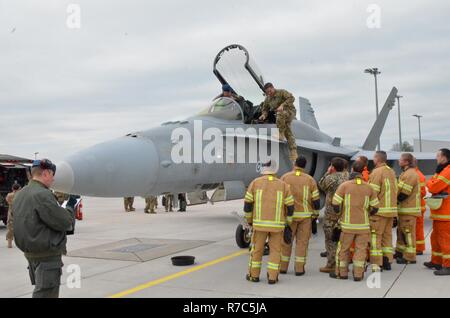 LIELVĀRDE, Latvia – Senior Master Sgt. Jeremy Wohlfore, with the Alpina Combat Readiness Training Center out of Michigan demonstrates how first responders would access the cockpit of a F/A-18 in the event of an emergency, May 18.  A Finnish F/A-18 Hornet tested out the arresting cable set-up and refueled at Lielvārde Air Base with the Latvian air force and Soldiers from 3rd General Support Aviation Battalion, 10th Aviation Regiment, 10th Combat Aviation Brigade, out of Fort Drum, N.Y., as part of Operation Atlantic Resolve. This is a new capability at Lielvārde that allows it to be more versat Stock Photo