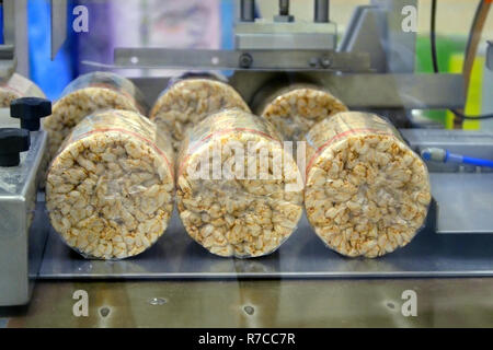 Food manufacture - Stack of puffed whole grain crispbread. packing organic multi barley briquetted crispbread on factory Stock Photo