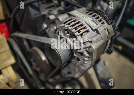 Grungy alternator on engine with belt on Stock Photo