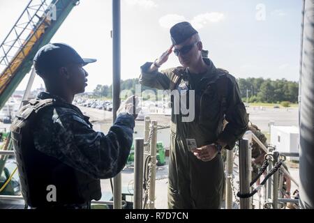 U.S. Navy CS2 Keenan Sutherland, a culinary specialist assigned to the USS Gunston Hall (LSD-44), salutes U.S. Marine Corps Capt. Stephan Whiteway, a pilot assigned to Marine Air Group 14, while boarding the ship during a Bold Alligator Aviation Mission Rehearsal Exercise at Joint Expeditionary Base Little Creek, VA, May 18, 2017. BAAMREX, a command post exercise for 2nd Marine Aircraft Wing command staff, is a joint exercise between the Navy and Marine Corps held at Expeditionary Warfare Training Group Atlantic. Stock Photo