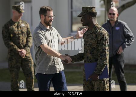Charles K. Hyde congratulates Lance Cpl. Samuel I. Jacksonwest during an award ceremony on Nov. 28, 2018 at Camp Foster, Okinawa, Japan. Jacksonwest received the 2018 Pacific Volunteer of the Year award for his 480 volunteer hours at the Camp Foster USO. Jacksonwest was the winner among 1,400 volunteers in the Pacific region and the first active duty volunteer to receive this award in the last 4 years. Jacksonwest, a native of Atlanta, Georgia, is a network administrator with Headquarters Company, Combat Logistics Battalion 4, Combat Logistics Regiment 3, 3rd Marine Logistics Group. Hyde, a na