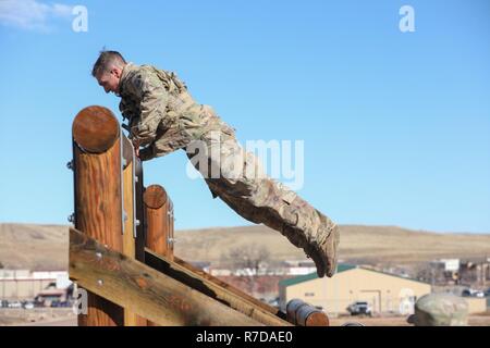 Staff Sgt. Levi McGowan, assigned to Bravo Company, 299th Brigade Engineer Battalion, 1st Stryker Brigade Combat Team, 4th Infantry Division, jumps to reach the end of an obstacle during the Best Sapper Competition, Fort Carson, Colorado, November 29, 2018. This year’s competition includes nine two-person teams from units across Fort Carson. The top three teams will go on to compete in the Army-wide Best Sapper Competition in April 2019 at Fort Leonard Wood, Missouri. Stock Photo