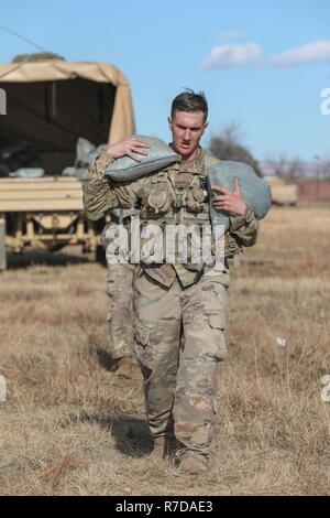 Staff Sgt. Levi McGowan, assigned to Bravo Company, 299th Brigade Engineer Battalion, 1st Stryker Brigade Combat Team, 4th Infantry Division, carries sand bags during the Best Sapper Competition, Fort Carson, Colorado, November 29, 2018. This year’s competition includes nine two-person teams from units across Fort Carson. The top three teams will go on to compete in the Army-wide Best Sapper Competition in April 2019 at Fort Leonard Wood, Missouri. Stock Photo