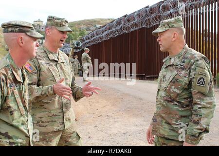 Col. Larry Dewey, 16th Military Police Brigade Commander, center, talks to Lt. Gen. Jeffrey Buchanan, United States Army North Commanding General, right, and Cpt. Charles Matthews, 104th Engineer Construction Company, left, about work complete on the border wall near Nogales, Arizona, Nov. 29, 2018. Northern Command is providing military support to the Department of Homeland Security and U.S. Customs and Border Protection to secure the southern border of the United States. Stock Photo