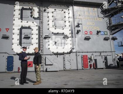 NORFOLK, Va. (Nov. 27, 2018) Capt. Kyle P. Higgins, commanding officer of the aircraft carrier USS Dwight D. Eisenhower (CVN 69), and Capt. Nick Cooke-Priest, commanding officer of the British aircraft carrier HMS Queen Elizabeth (R08) speak on the flight deck. Ike is undergoing a Planned Incremental Availability (PIA) during the maintenance phase of the Optimized Fleet Response Plan (OFRP). Stock Photo