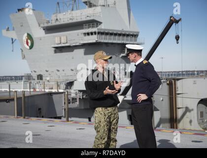 NORFOLK, Va. (Nov. 27, 2018) Capt. Kyle P. Higgins, commanding officer of the aircraft carrier USS Dwight D. Eisenhower (CVN 69), and Capt. Nick Cooke-Priest, commanding officer of the British aircraft carrier HMS Queen Elizabeth (R08) speak on the flight deck. Ike is undergoing a Planned Incremental Availability (PIA) during the maintenance phase of the Optimized Fleet Response Plan (OFRP). Stock Photo