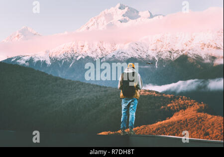 Man piloting drone in sunset mountains blogger adventure travel lifestyle winter vacations outdoor hiking alone modern technology hobby Stock Photo