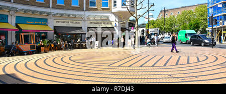 Paving stones circle in front of Wimbledon London street scene in shopping area laid to circular geometric pattern contrast colour stripes England UK Stock Photo