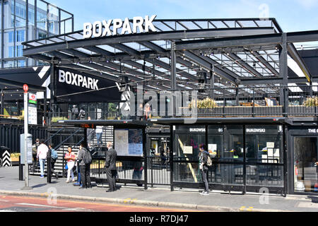 London street scene people wait at public transport bus stop at Boxpark food & retail business built from shipping containers East Croydon England UK Stock Photo