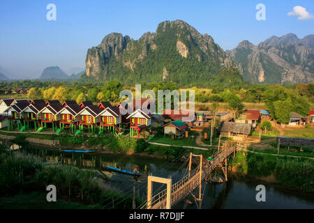 Row of tourist bungalows along Nam Song River in Vang Vieng, Vientiane Province, Laos. Vang Vieng is a popular destination for adventure tourism in a  Stock Photo