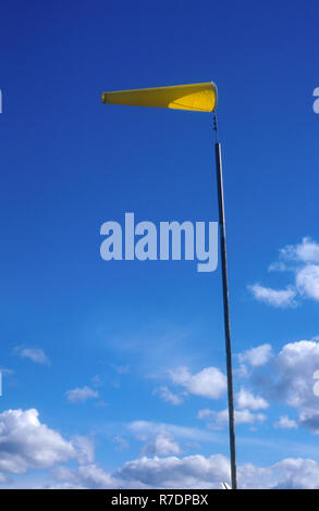 A WINDSOCK CAN USED BY PILOTS FOR MEASURING WIND DIRECTION AND SPEED AS WELL AS LOCATED ALONGSIDE HIGHWAYS AT WINDY LOCATIONS. SHOWN HERE IN HIGH WIND. Stock Photo