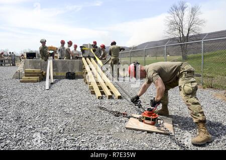 Soldiers with the 228th Engineer Company, Pennsylvania National Guard, honed their disaster response skills at Fort Indiantown Gap's structure collapse site April 11, 2017. The Soldiers, part of the Chemical, Biological, Radiological, Nuclear and Enhanced Conventional Weapons Task Force search and extraction section, used their specialized equipment to safely remove a heavy piece of debris, which in a disaster situation, would impede rescue efforts for individuals trapped in a collapsed building. Stock Photo