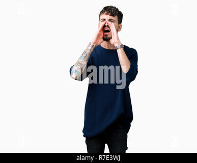 Young handsome man over isolated background Shouting angry out loud with hands over mouth Stock Photo