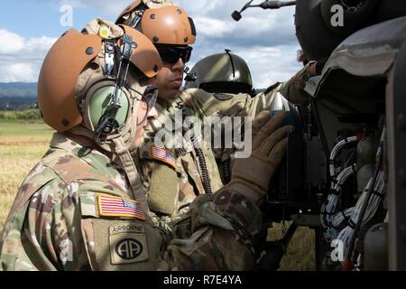 U.S. Army Soldiers assigned to 2nd Squadron, 6th Calvary Regiment, 25th Combat Aviation Brigade, 25th Infantry Division, load 30-millimeter M788 training purpose rounds in a AH-64 Apache helicopter in preparation for aerial gunnery qualification at a forward arming and refueling point on Schofield Barracks, Hi., Nov. 29, 2018. The cannon fires the M799 high explosive incendiary round and the M789 high explosive dual purpose round that can penetrate more than 2 inches of armor at 2,500 meters. Stock Photo