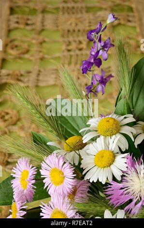 Wild flowers on beige embroidered background Stock Photo