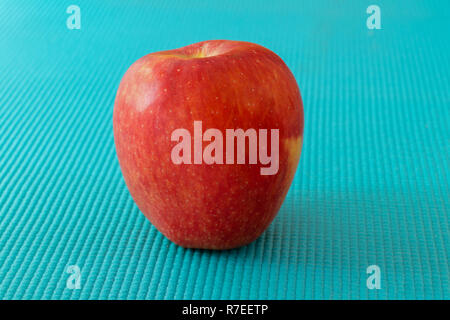 Red apple on sky blue texture surface Stock Photo