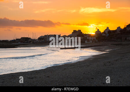 Lyme Regis, Dorset, UK.  9th December 2018. UK Weather.  The sky turns orange at sunset at Lyme Regis in Dorset at the end of a cold breezy sunny afternoon.  Picture Credit: Graham Hunt/Alamy Live News Stock Photo