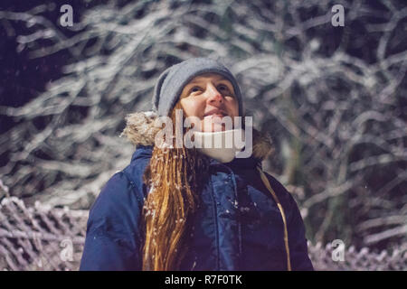 Young girl at night in winter looking up Stock Photo