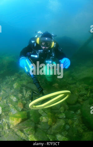 Diver with metal detector searching for underwater treasure, Lake Baikal, Siberia, Russia Stock Photo