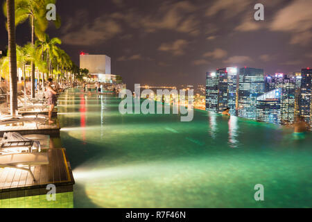 Downtown central financial district at night viewed from the Infinity pool of the Marina Bay Sands, Singapore Stock Photo