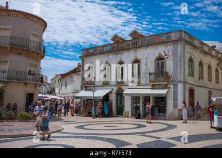 Lagos, Portugal - June 27, 2018: Tourists stop at stores lined along the tiled streets of Lagos on a sunny day. Stock Photo