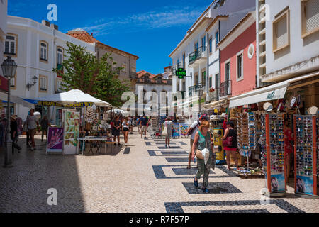 Lagos, Portugal - June 27, 2018: Tourists stop at stores lined along the tiled streets of Lagos on a sunny day. Stock Photo