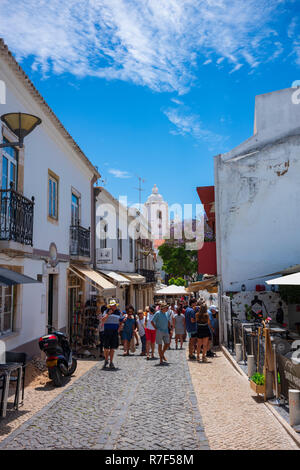 Lagos, Portugal - June 27, 2018: Tourists stop at stores lined along the tiled streets of Lagos on a sunny day. Stock Photo