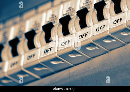 Electricity breakers on an old UK household fuse box with colour toning Stock Photo